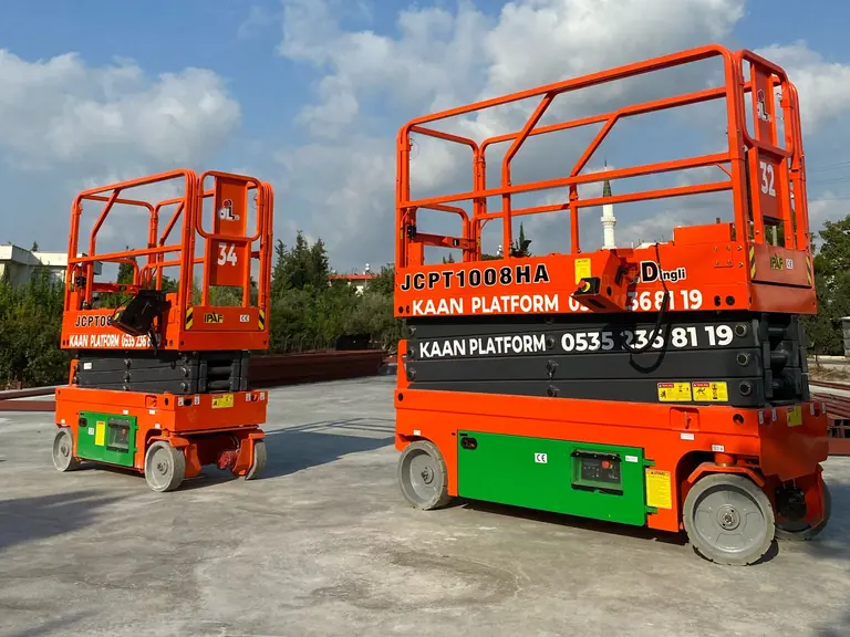 Açık sahada turuncu akülü makaslı platformlar