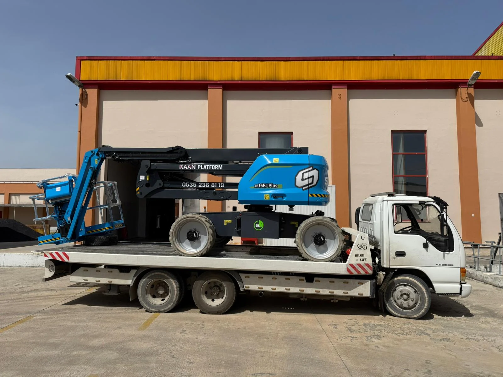 Manlift Kiralama Nakliye aracındaki mavi manlift platformu