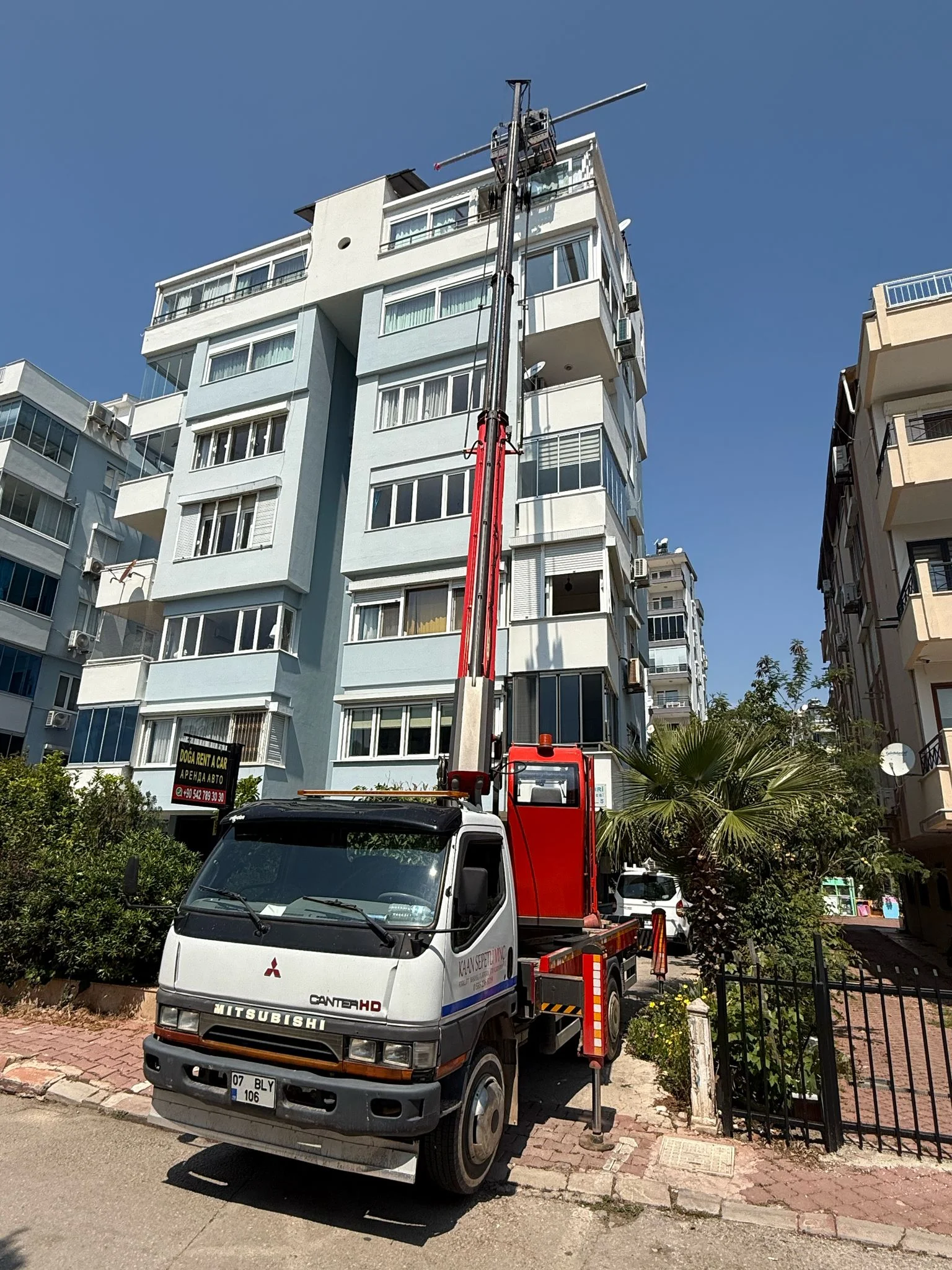 Sepetli Vinç Kiralama Apartman cephesinde çalışan araç üstü sepetli vinç